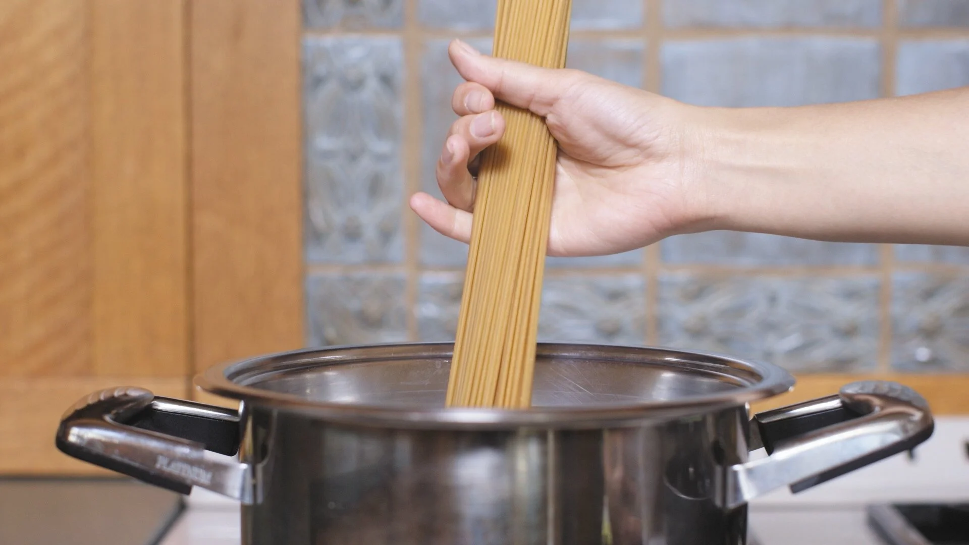 Production still, spaghetti being placed in boiling water