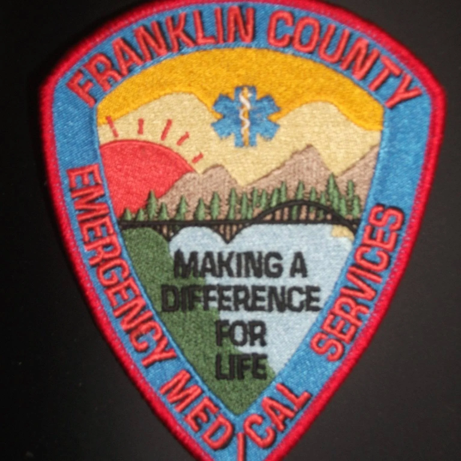 Patch for Franklin County Emergency Services with mountains, sunrise, trees, and a blue star of life, with the slogan 'Making a Difference for Life' and surrounding text indicating emergency response and safety.
