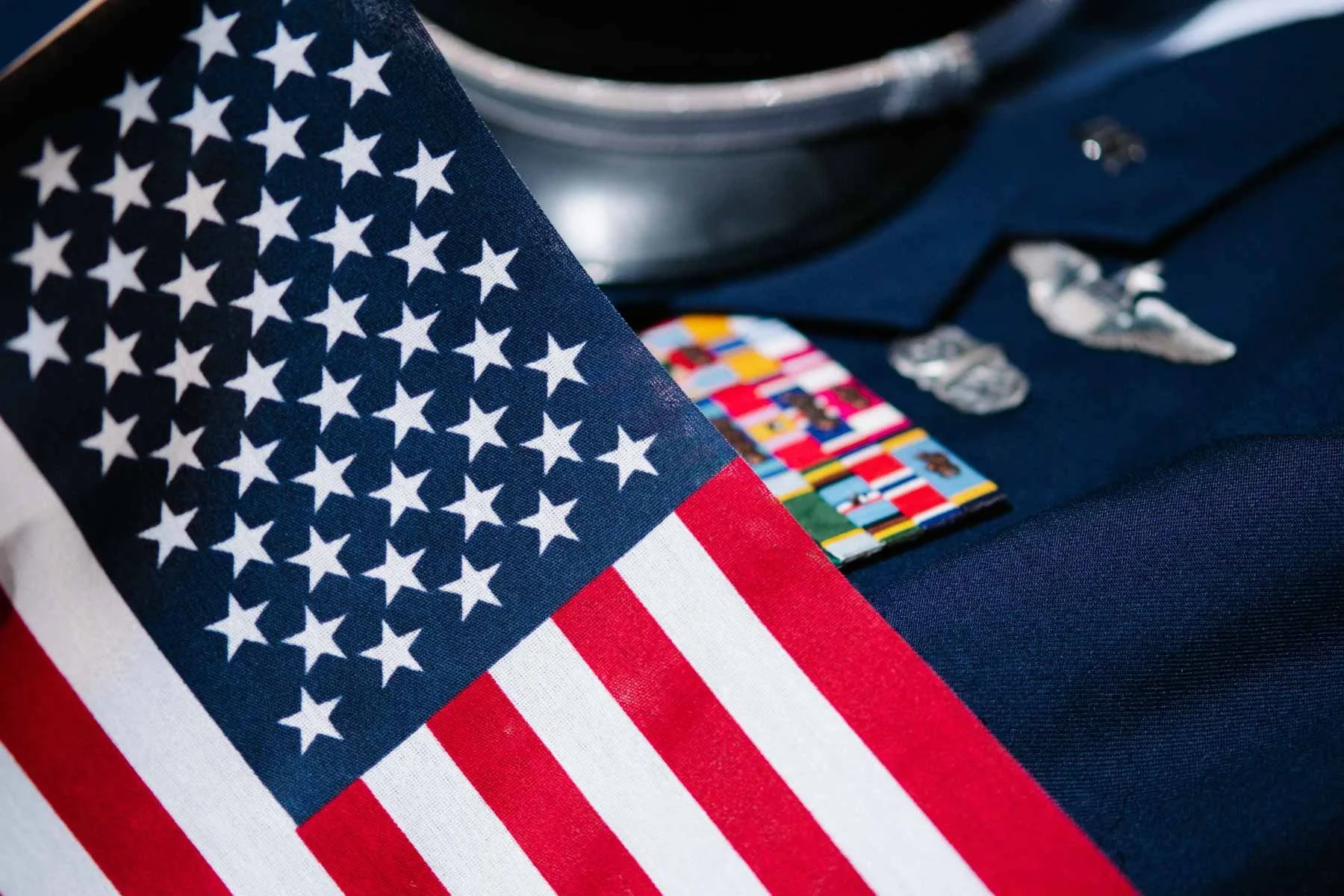 American flag in front of a military dress uniform.