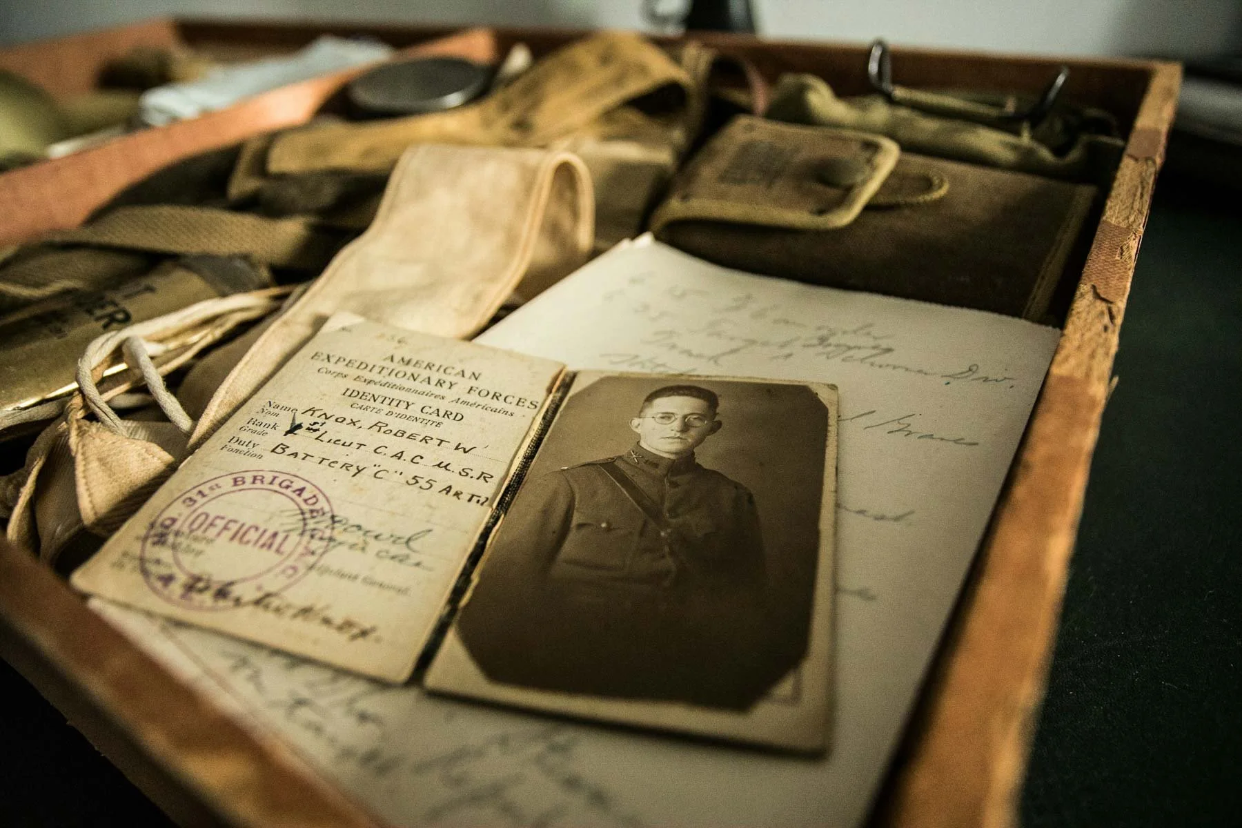 Historical identification card of an American soldier on a table of historical artifacts.