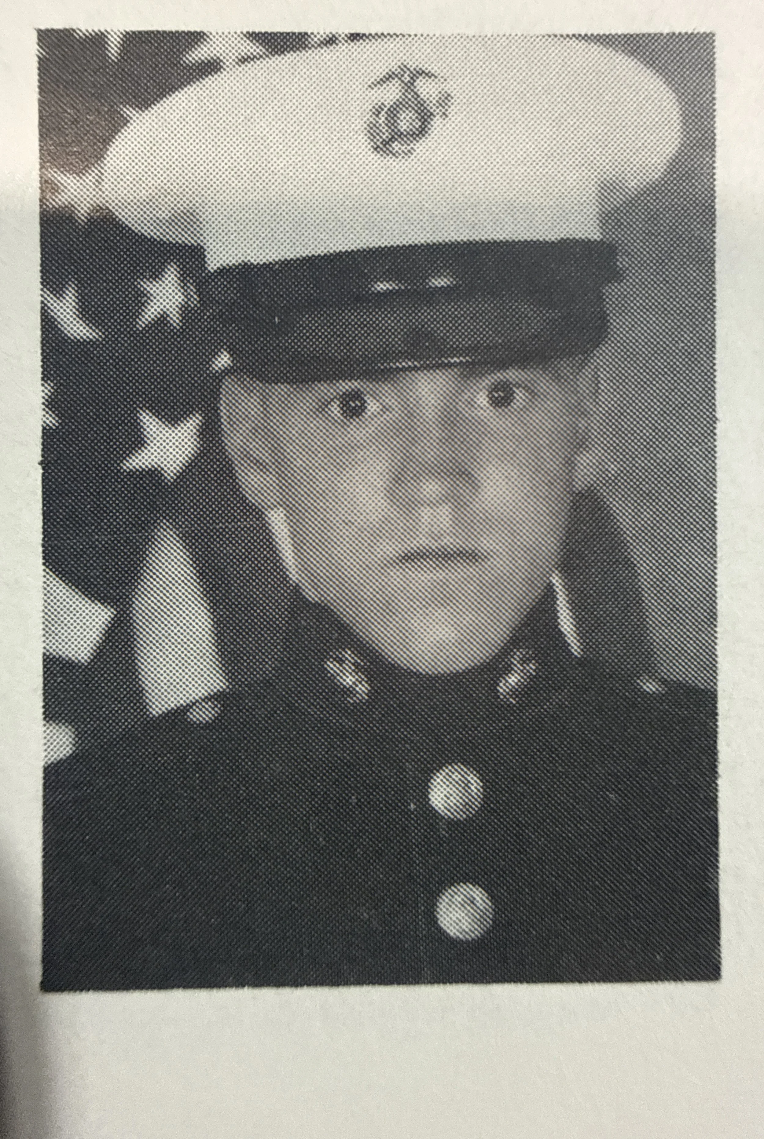 An old polaroid of a soldier in front of an American flag.