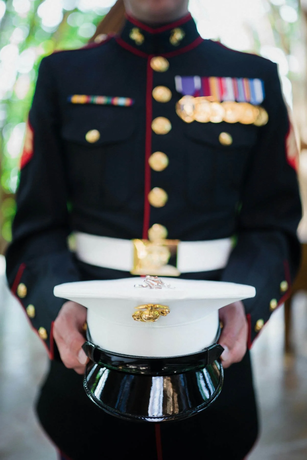 A soldier in full dress uniform holding his cover.
