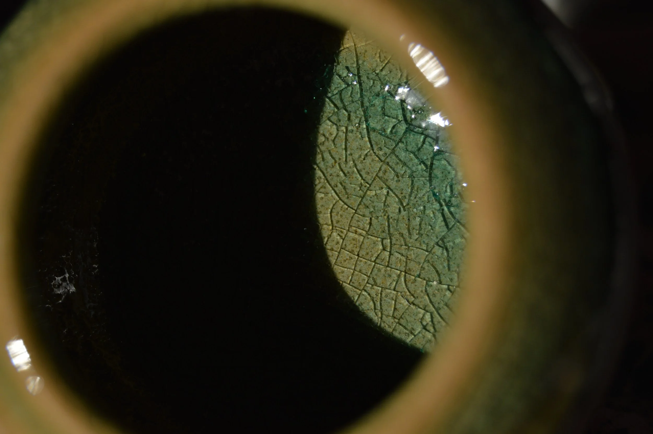 Vista attraverso un bicchiere di vino che mostra un tappo con una rete di crepe e alcune tracce di umidità.