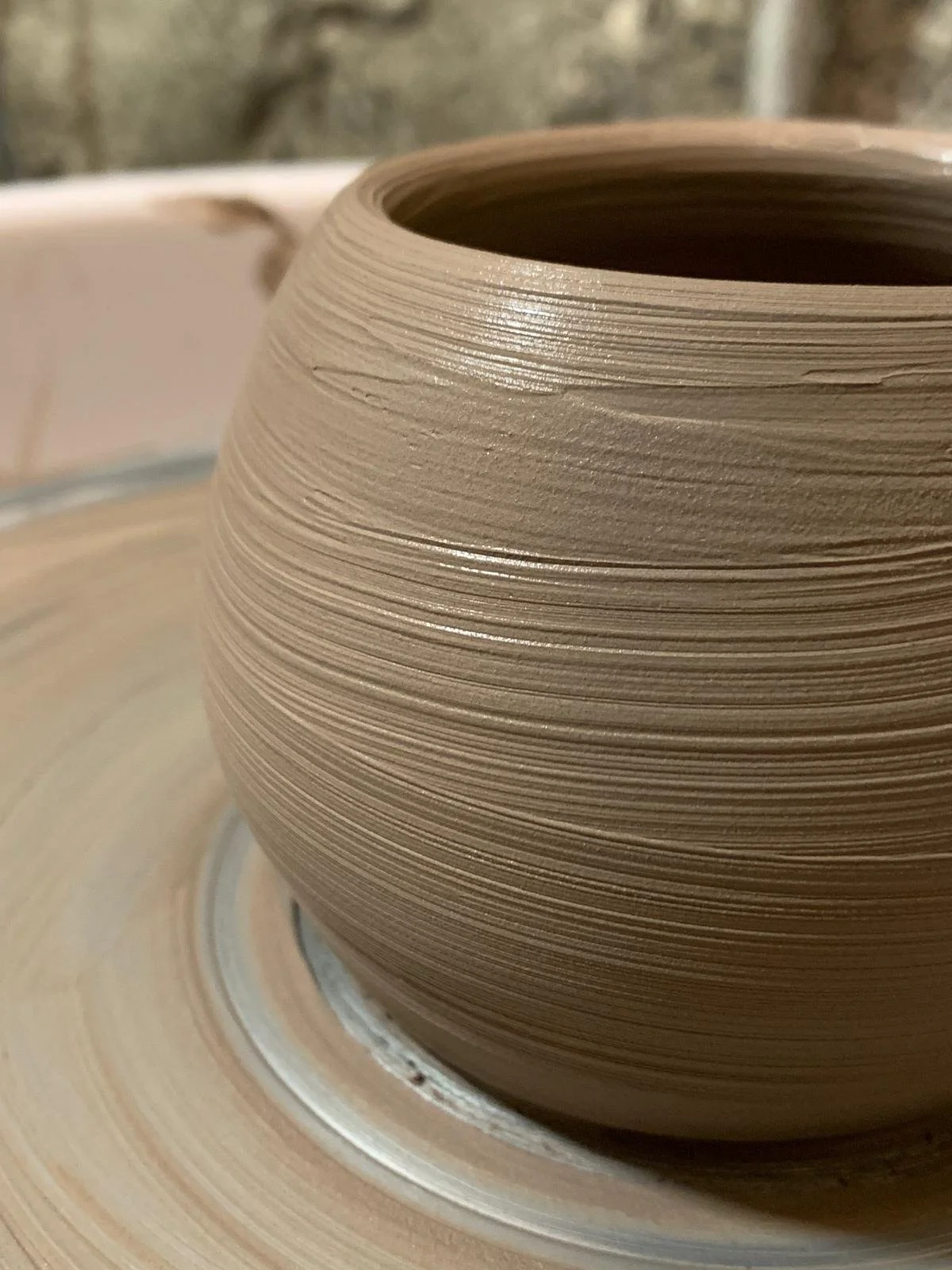 Vaso di argilla in fase di lavorazione sulla ruota di una ceramica