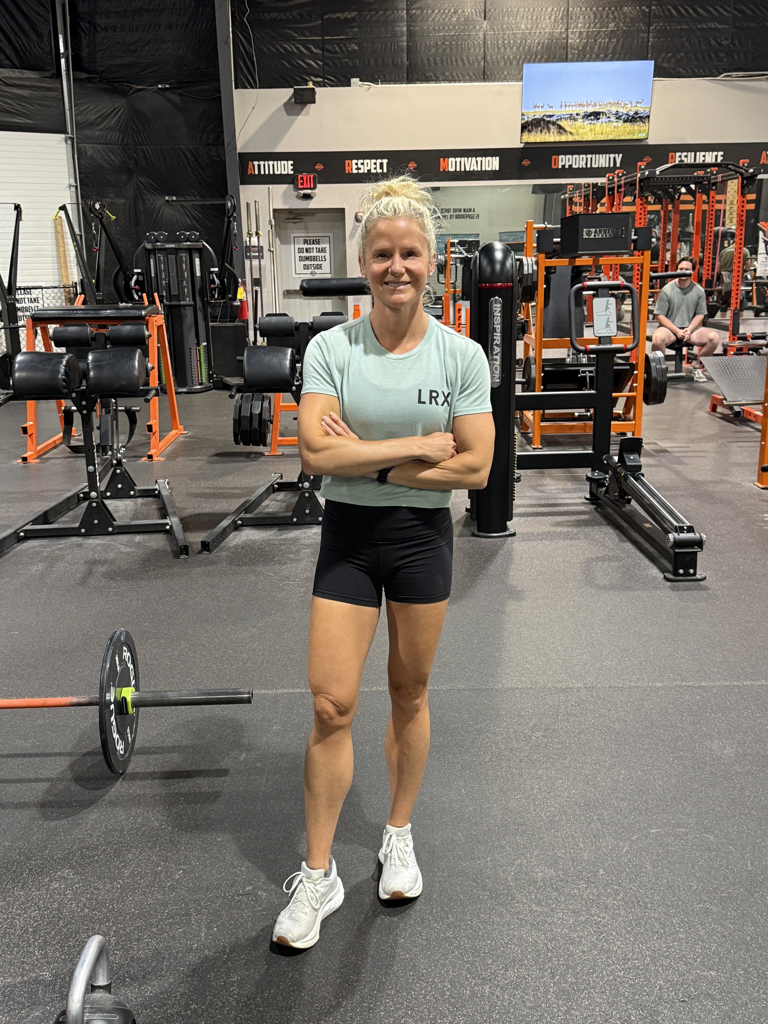 Female strength coach for women over 35 smiling in gym.