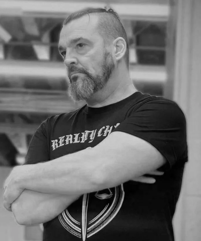 Reality Check Founder Jay Cooper observing a training session in a gym environment focused on practical skills
