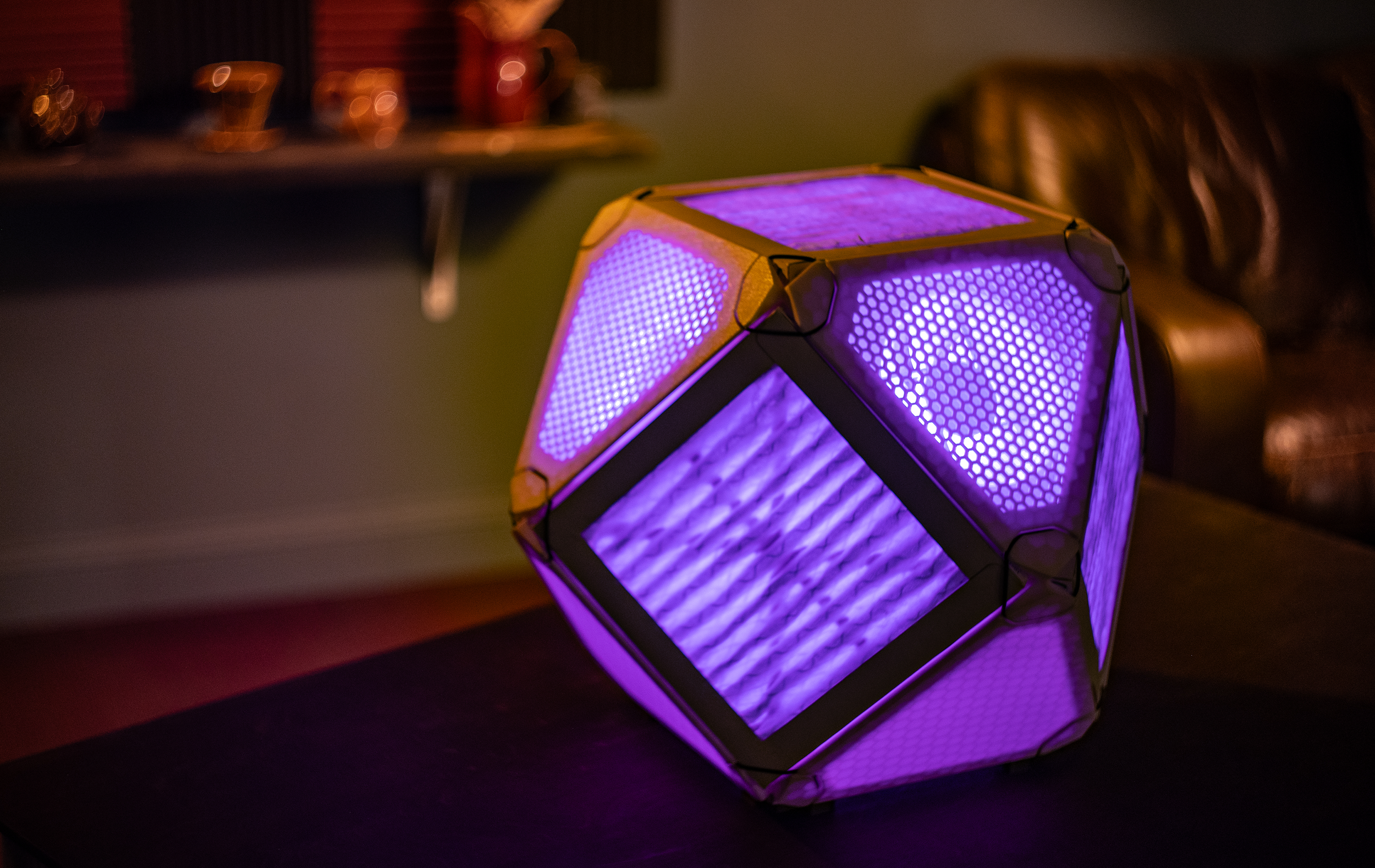 Glowing purple OddCube Air Purifier on a table