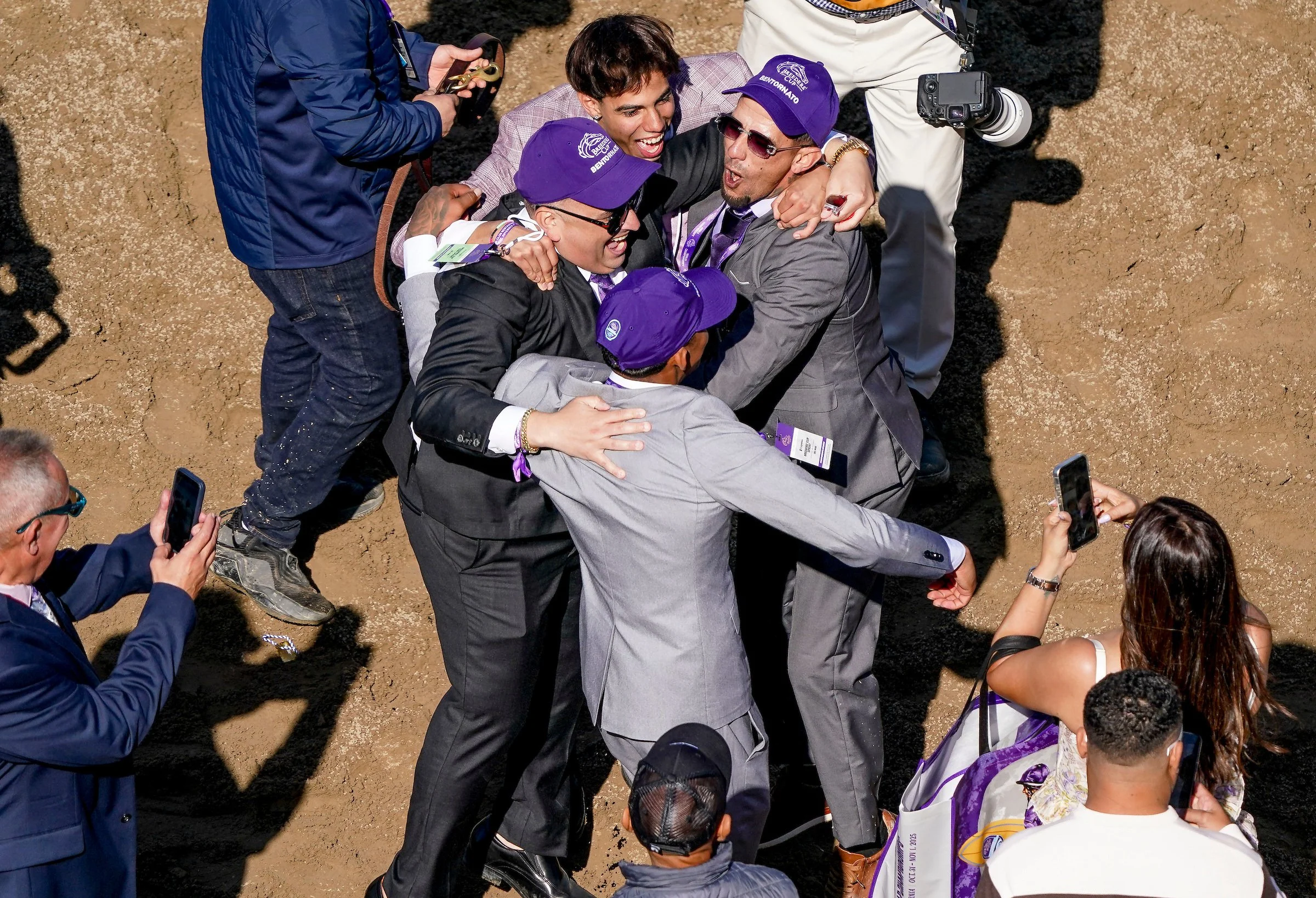 Group of racehorse owners celebrating together after a win, showing the emotional highs of ownership