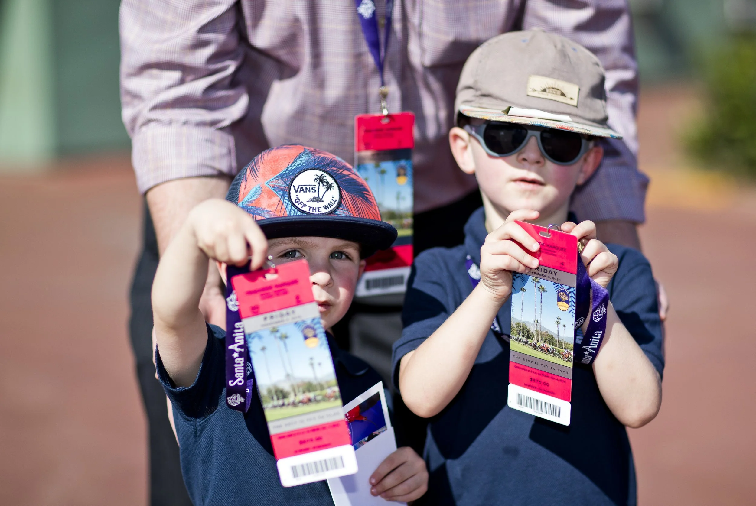 Kids holding racetrack credentials, showing the accessible and family-friendly side of getting started in racehorse ownership