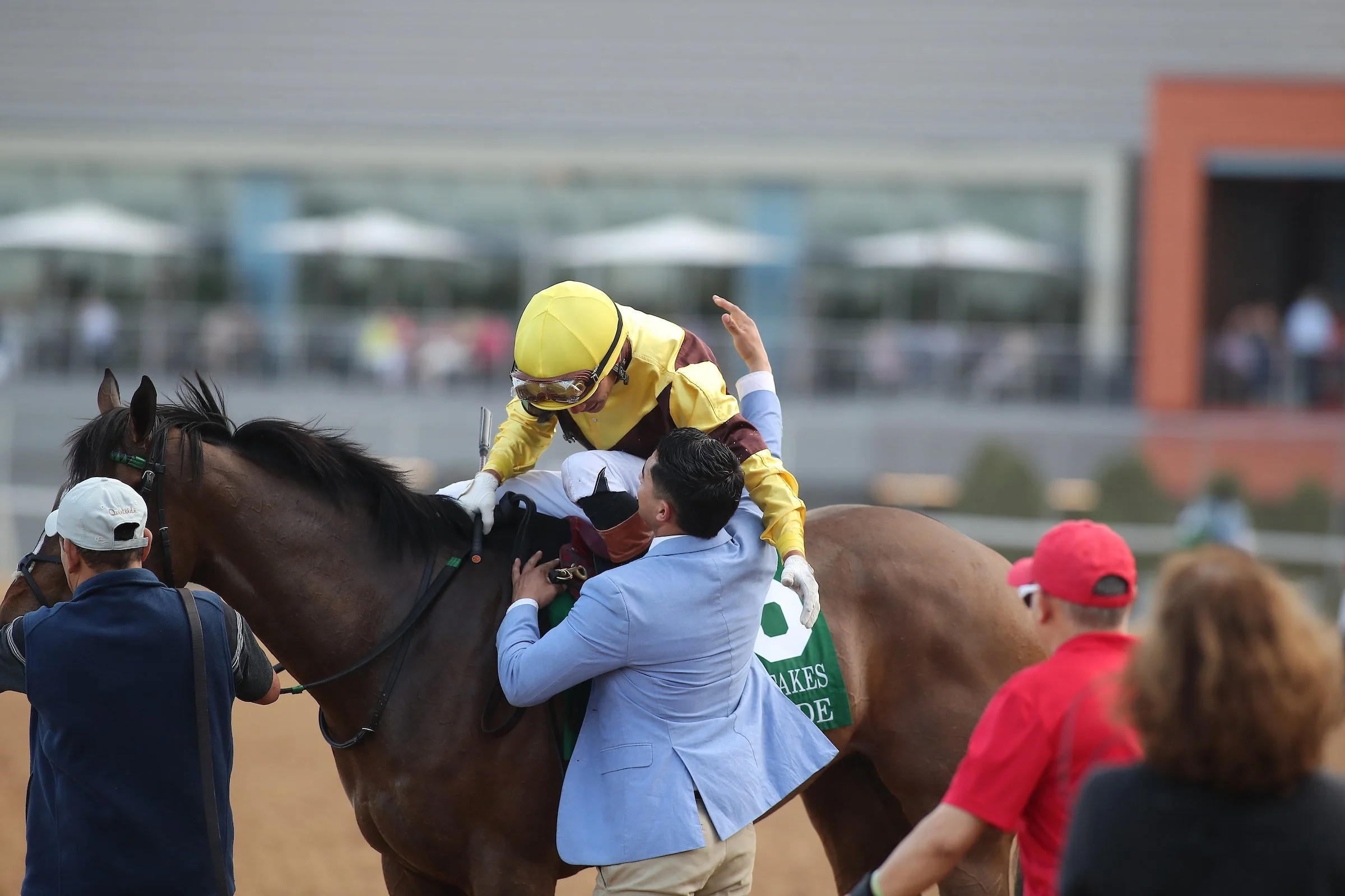 Racehorse owner greeting a jockey after a race, showing the accessible and personal side of horse racing through America’s Best Racing