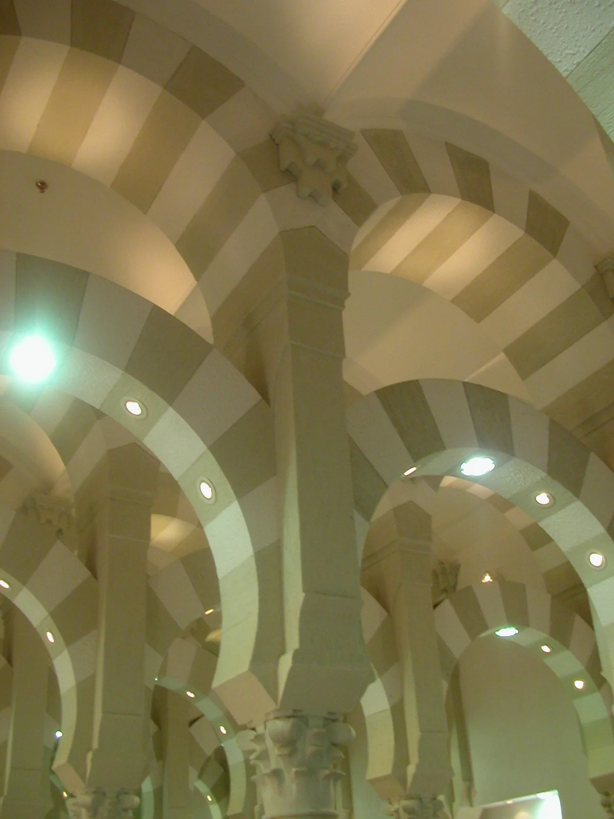 Interior view of a corridor or hall with arched ceilings, checkered pattern, and decorative columns.