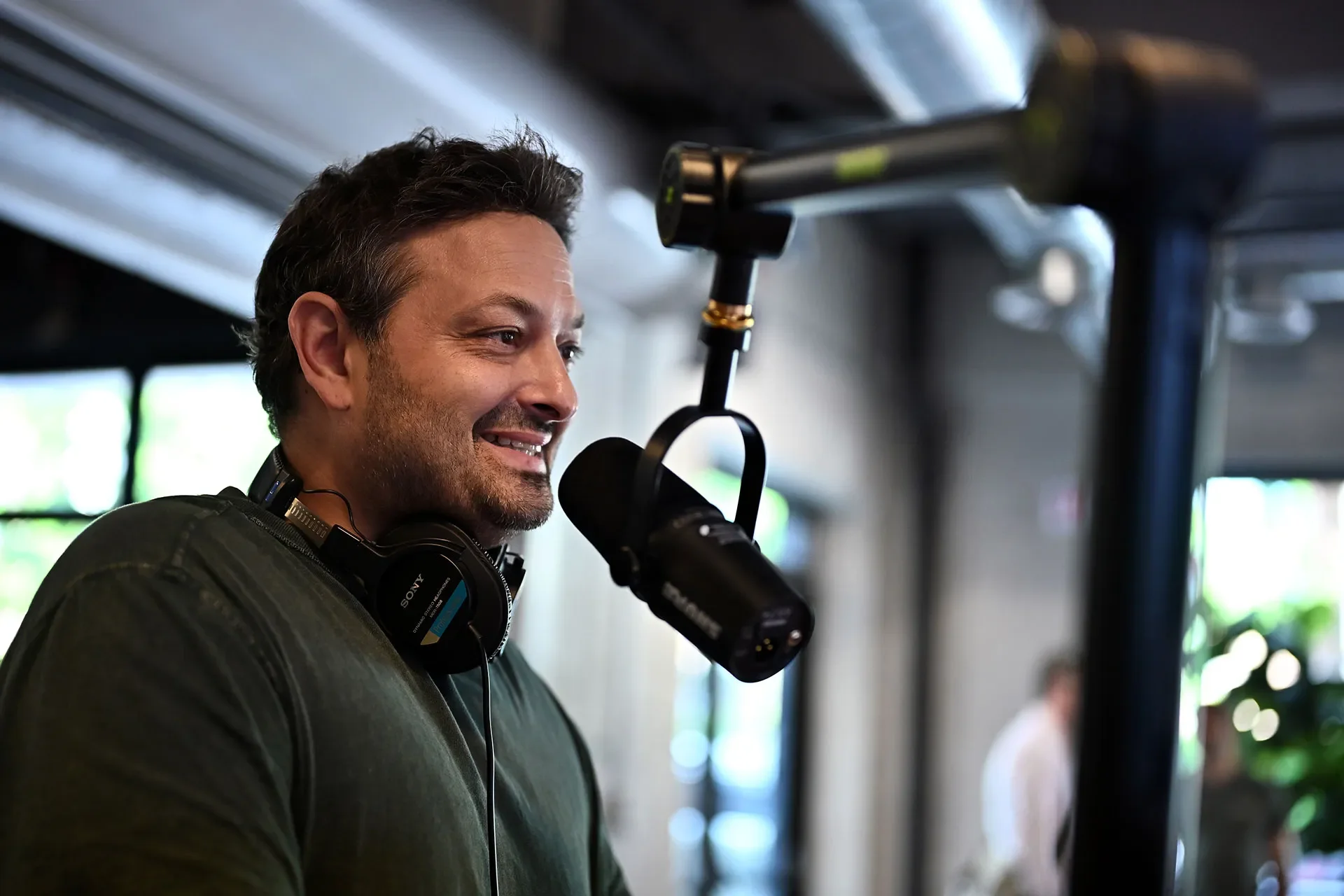 Jimmy sitting in front of a podcast microphone