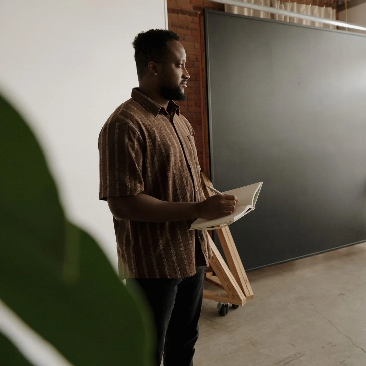 A therapist taking notes on a notepad and looking off into the distance