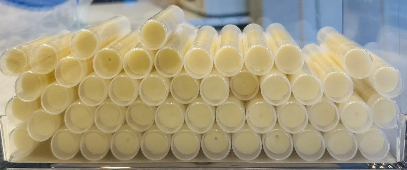Stacked yellow lip balm tubes.