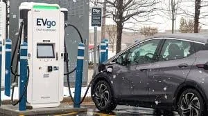 Electric car charging at a station during winter