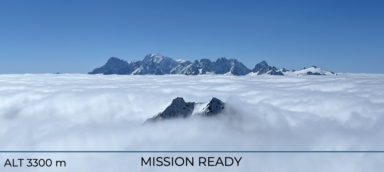 Snow-covered mountain peaks above a sea of clouds with a clear blue sky, indicating a high-altitude location at 3300 meters, with text 'MISSION READY'.