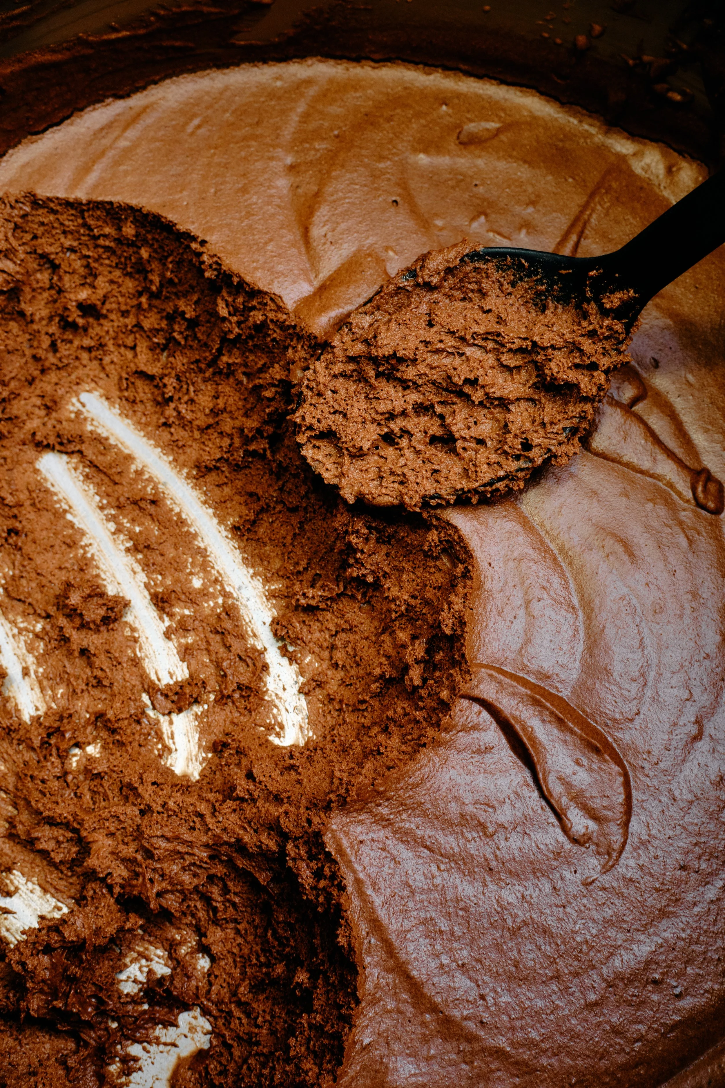 Mousse au chocolat avec trace de cuillère, montrant la texture moelleuse et la garniture au chocolat.