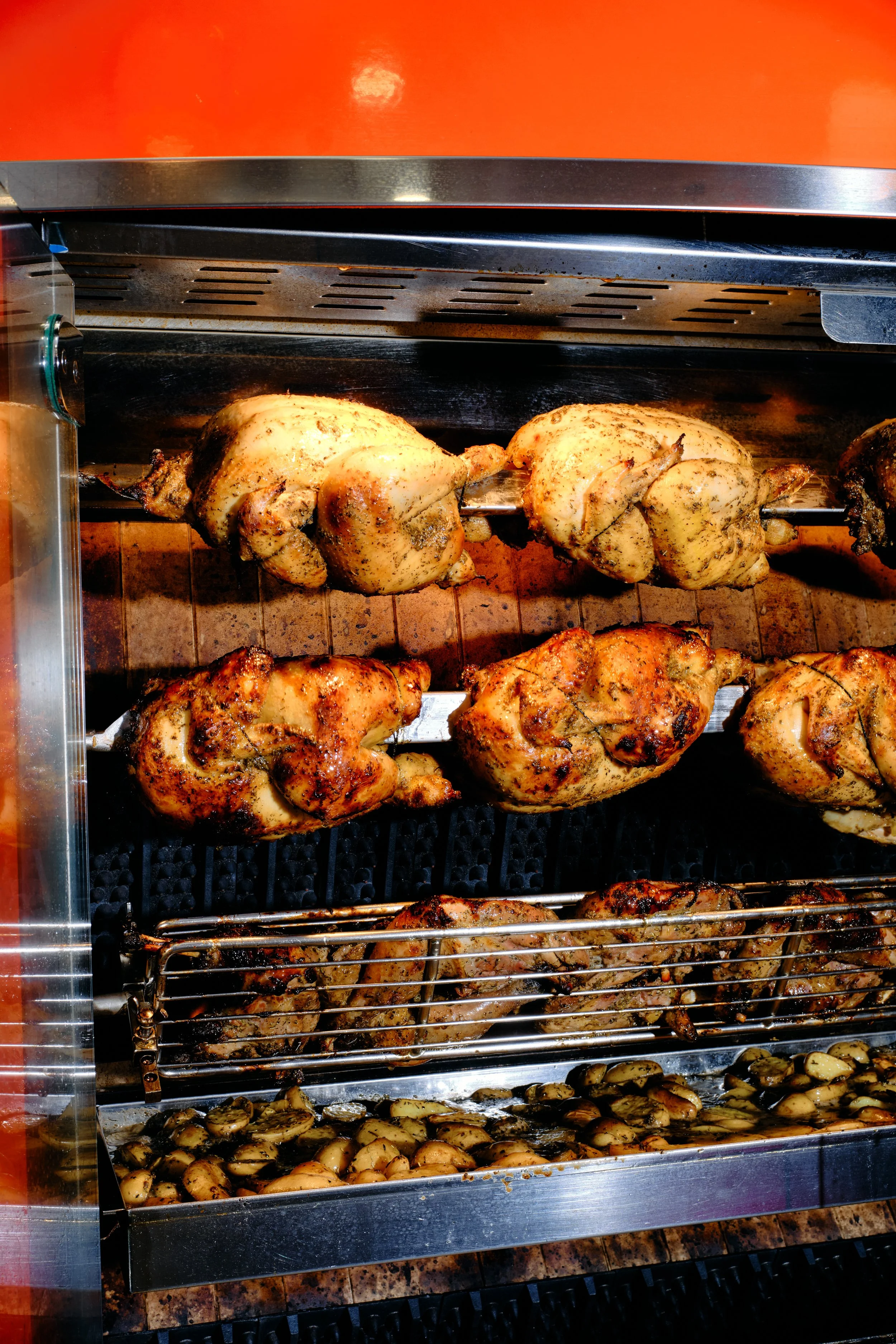 Poulet rôti, pommes de terre, et autres légumes dans une rôtissoire.