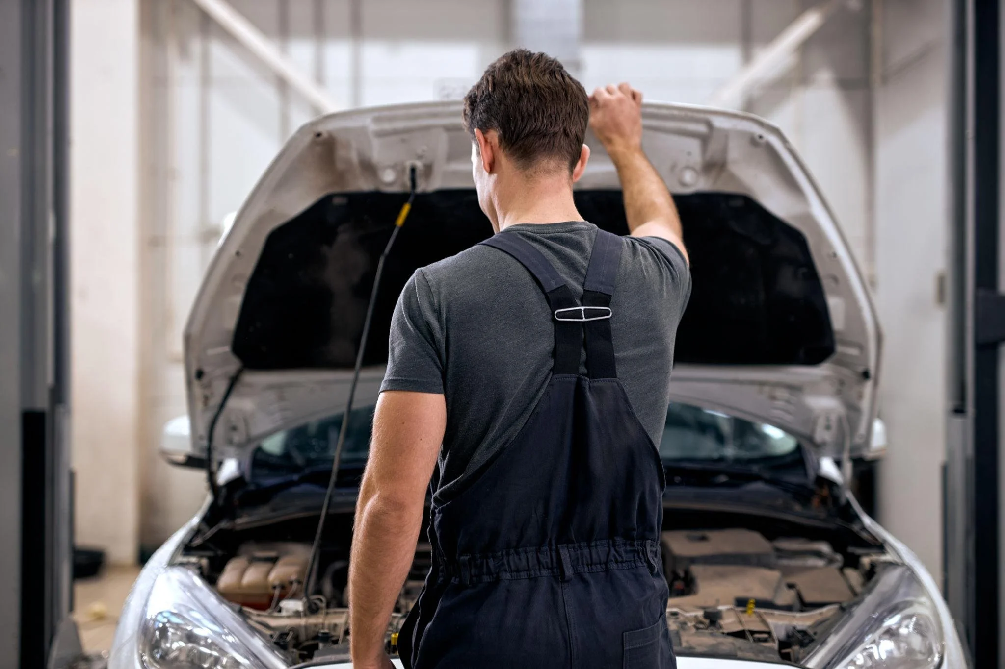Mechanic working under a lifted car at an auto repair shop; Avalon Advisory provides bookkeeping for automotive businesses around Mooresville (aka Race City USA) and Troutman.