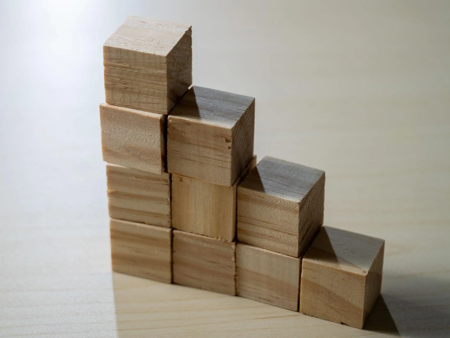 Series of stacked wooden blocks forming ascending steps illustrating Avalon Advisory’s service levels, from foundational bookkeeping to high‑touch support.