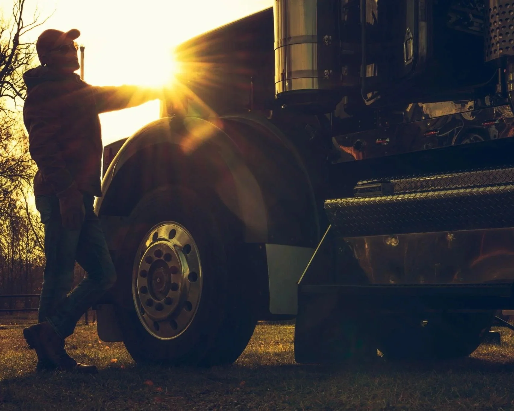 Owner operator standing beside semi truck front tire trucking business north carolina