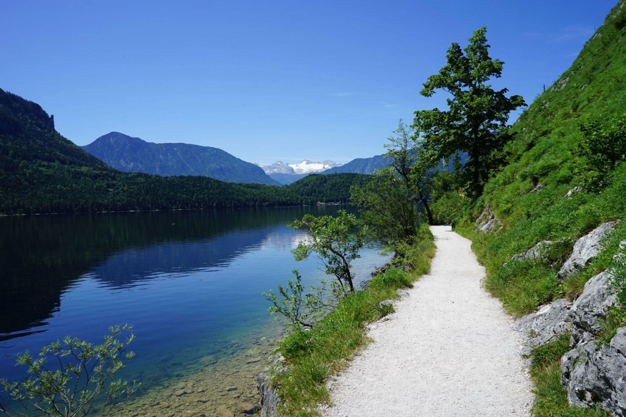 Clear gravel path beside a turquoise lake leading toward mountains, representing transparent, stress‑free bookkeeping guidance for businesses in Iredell County.