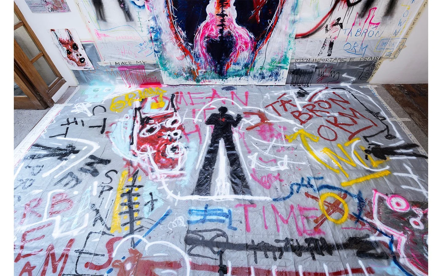 Detail of painted floor installation by PIGSY, showing layered text, symbols and gestural mark-making within “Tá Brón Orm” exhibition