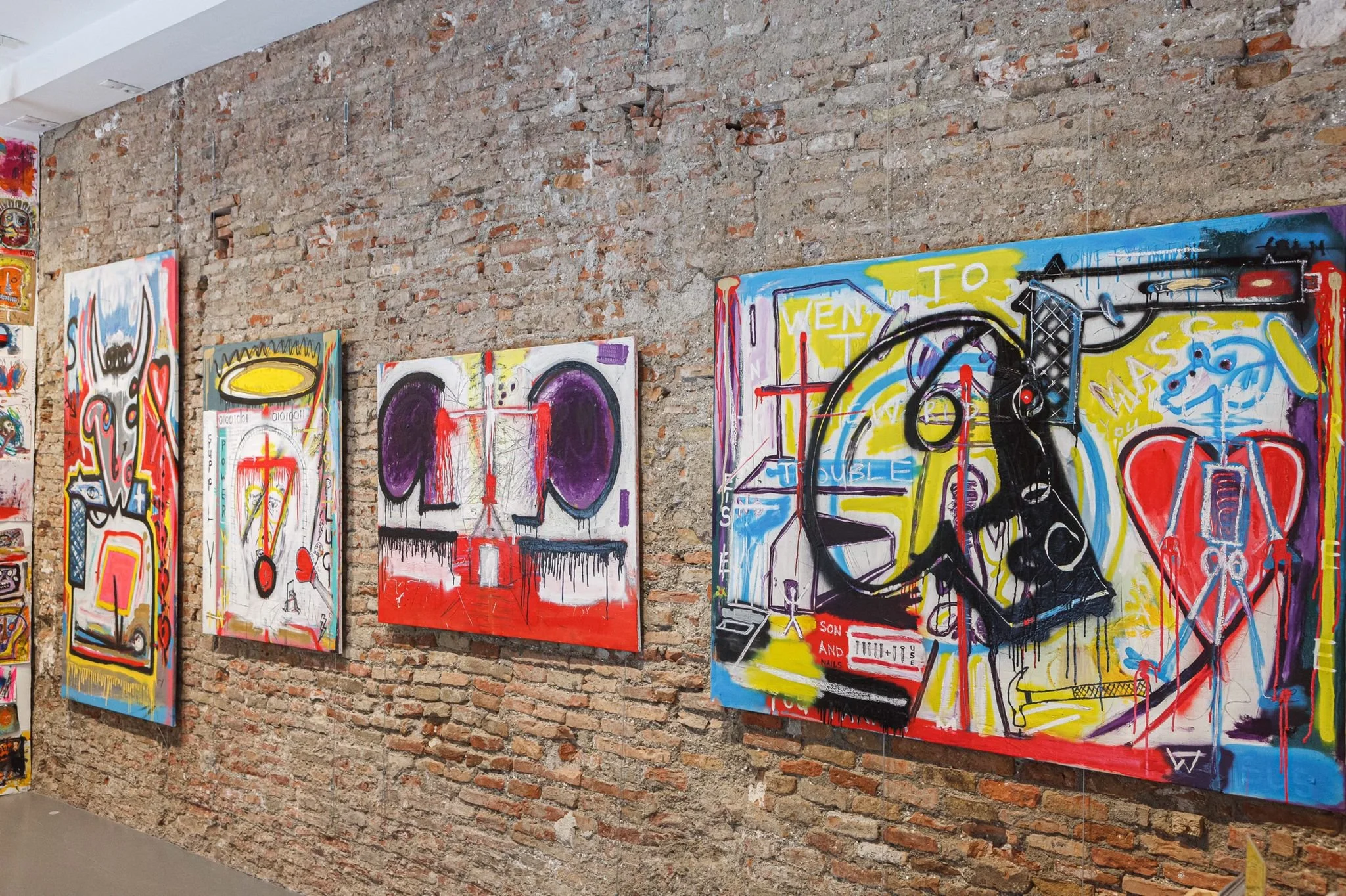 Installation view of PIGSY “I Went To Mass” exhibition at La Casa Amarilla, Malaga 2021, featuring large figurative paintings and salon-style drawings on brick wall