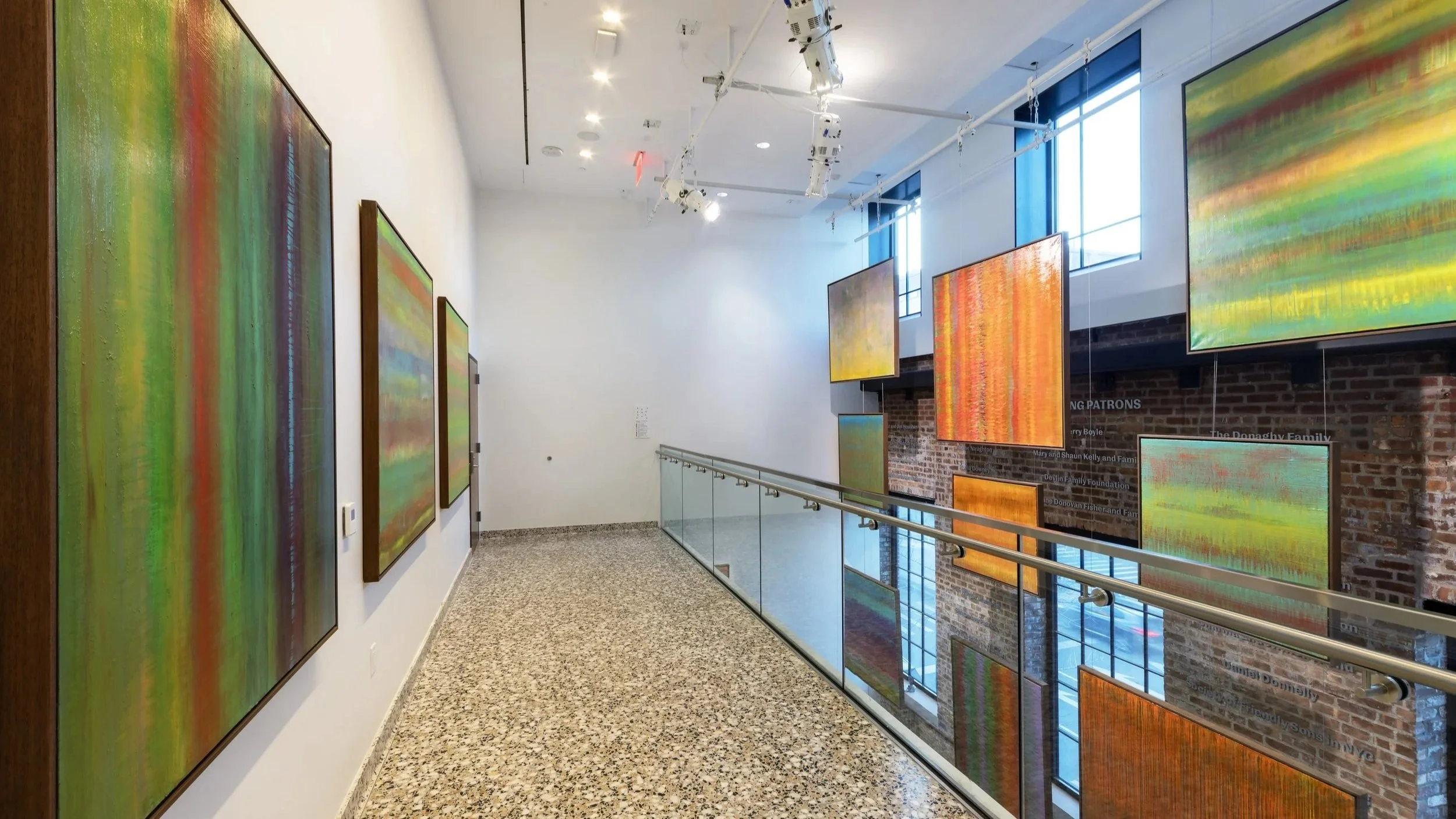 Installation view of Paul Hughes exhibition featuring large abstract colour field paintings in gallery space with suspended works and mezzanine walkway
