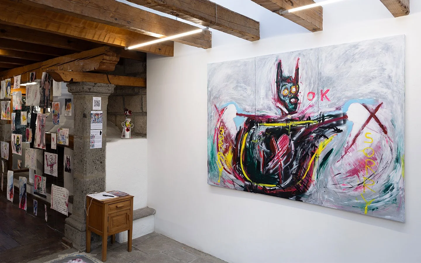 Large-scale figurative painting by PIGSY featuring expressive mark-making, symbolic forms and text elements including “SORRY”, installed within exhibition space