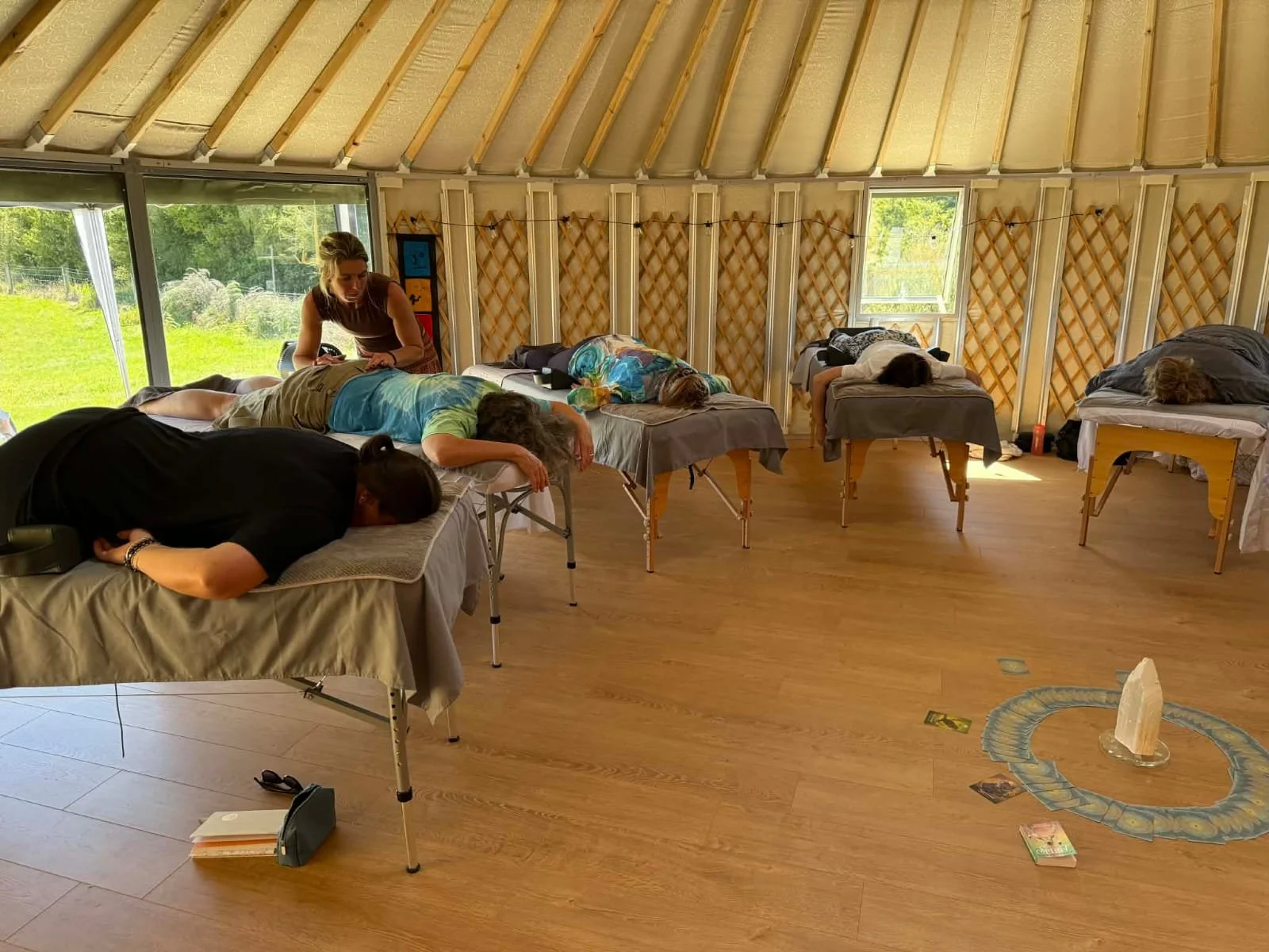 Practitioner facilitating a somatic release session on a massage table during a specialized healing retreat.