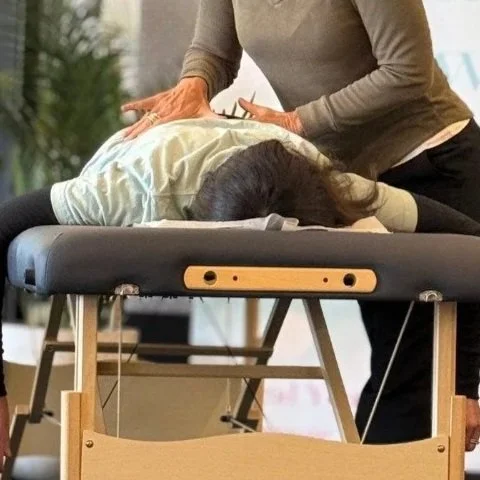 Jayne Birkett performing a Spinal Flow Technique session to help a client with nervous system regulation in her Hamilton studio.