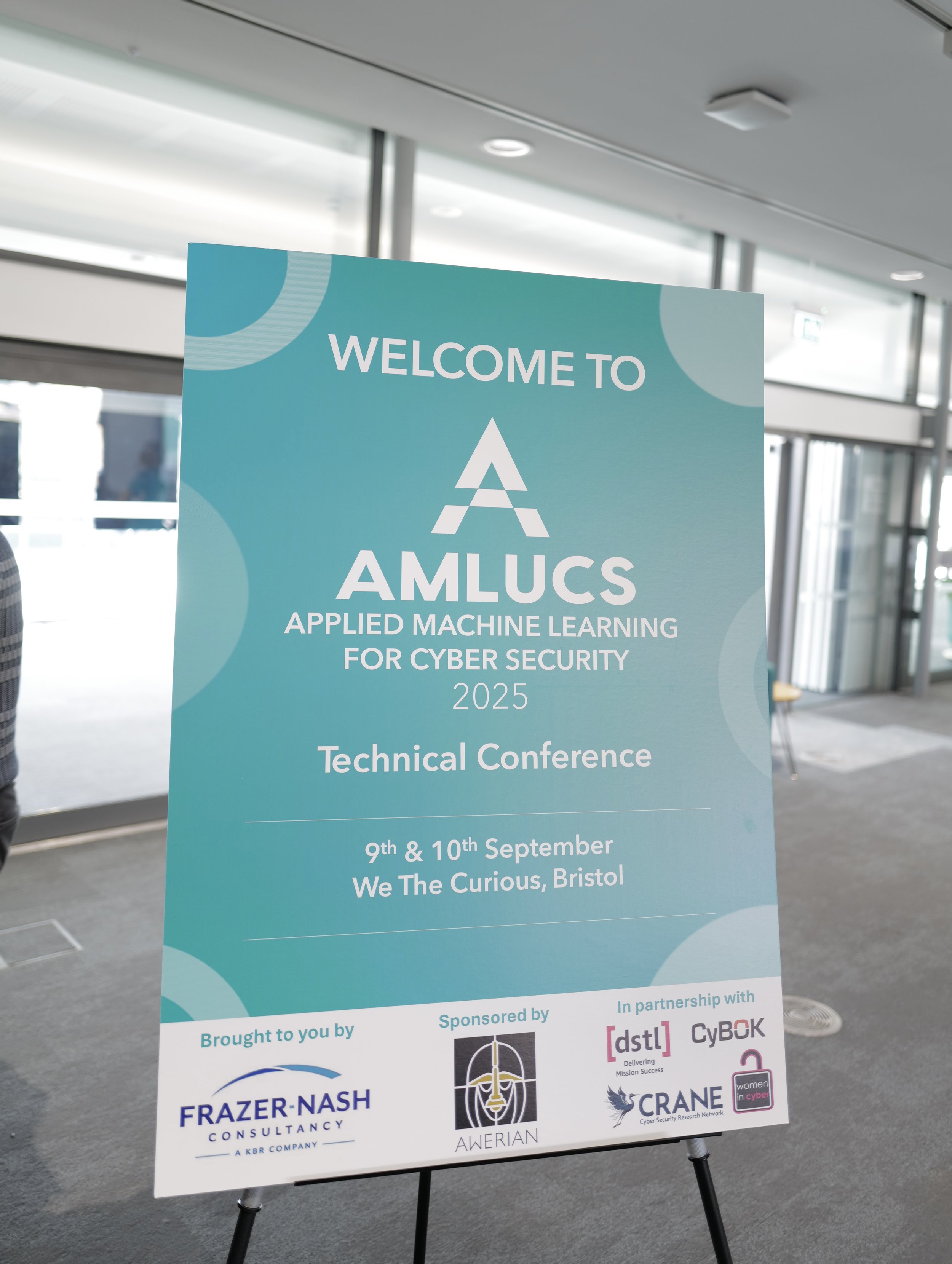 Conference sign for AMLUC 2025, Applied Machine Learning for Cyber Security, held on September 9th and 10th at We The Curous, Bristol.