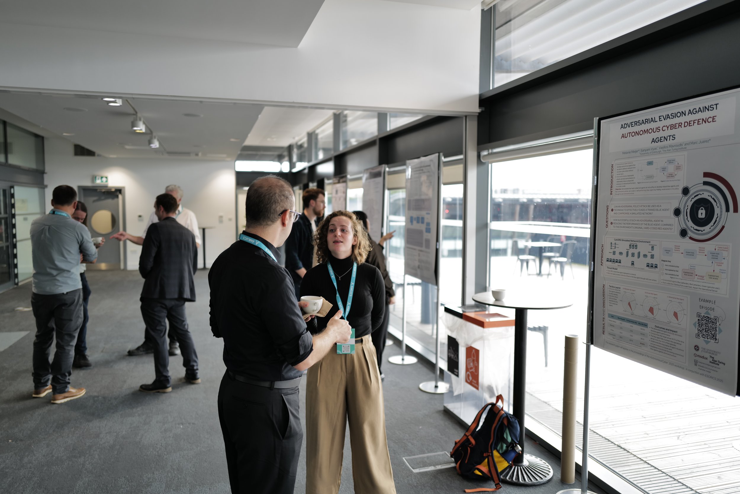 People attending a conference and viewing research posters in a modern, well-lit conference hall with large windows.