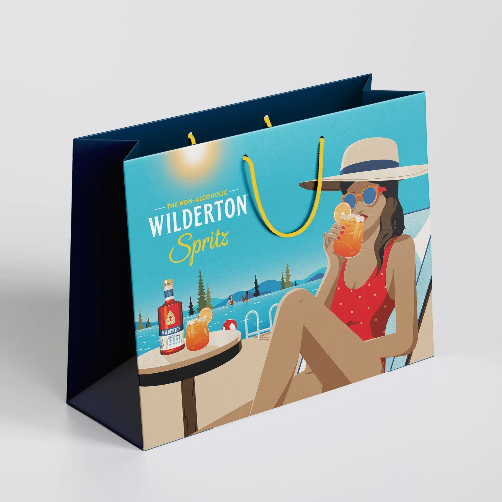 A colorful paper shopping bag featuring an illustration of a woman in a red bathing suit and wide-brimmed hat relaxing by a poolside with a drink and sunglasses, with a bottle of Wilderton Spritz on the table.