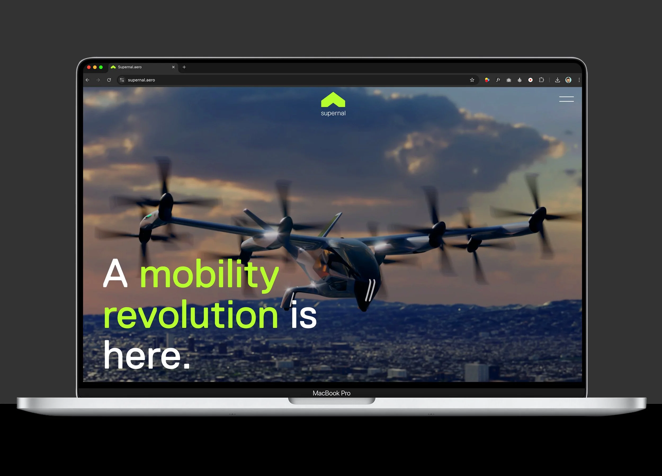 A MacBook Pro laptop displaying a website with a drone flying against a cityscape during sunset, with the text 'A mobility revolution is here.'
