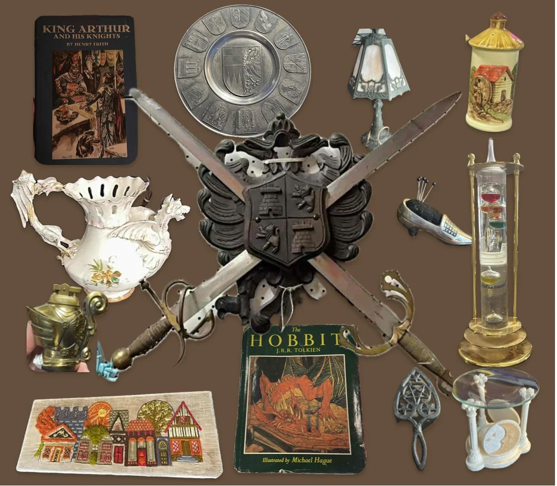 A collection of vintage and fantasy-themed objects arranged on a brown background, including a book titled "King Arthur and His Knights," a Tolkien "The Hobbit" book, a decorative shield with crossed swords, a porcelain teapot, a pocket watch, a miniature house, jewelry, a lamp, a glass display, a small mosaic, and various other antique items.