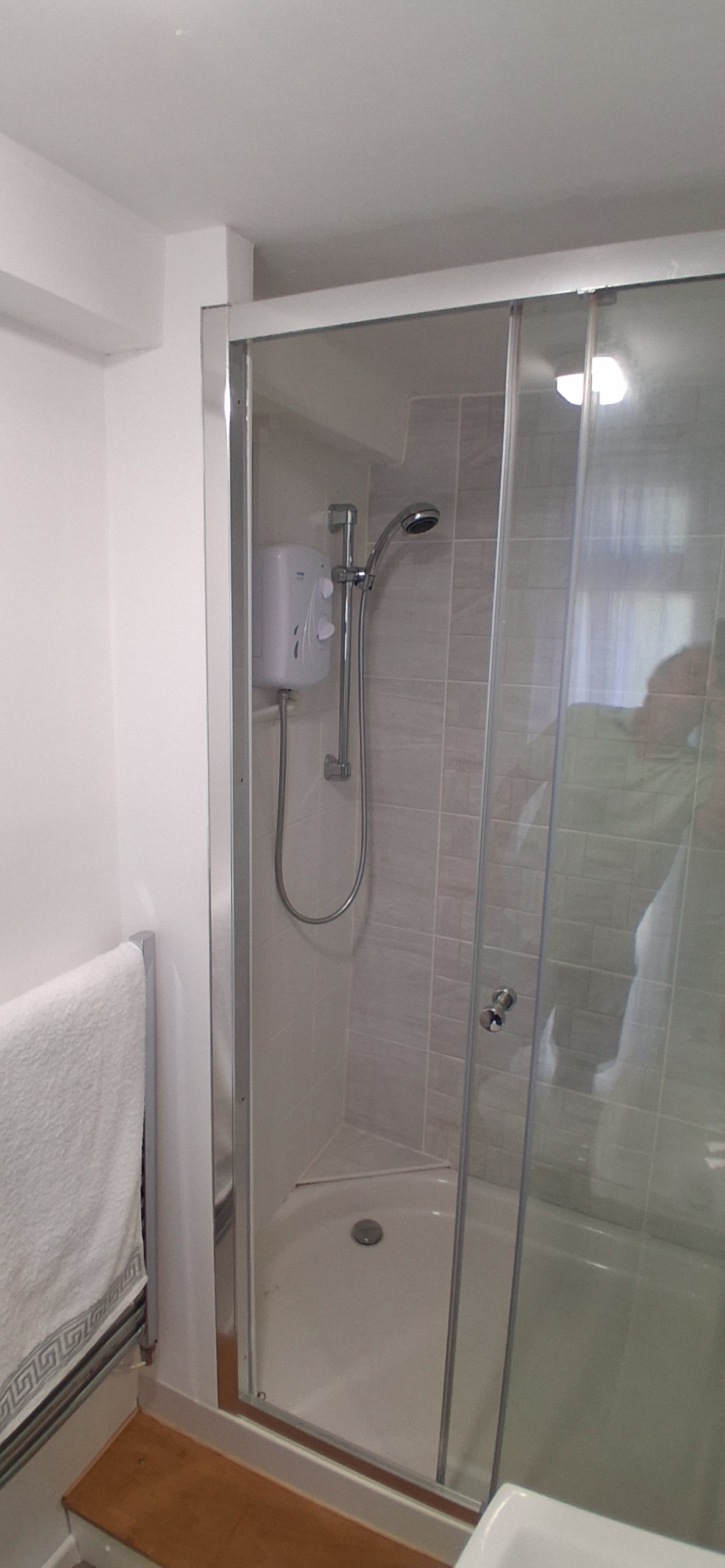 Clean en-suite bathroom walk-in shower in a self-catering holiday lodge rental.