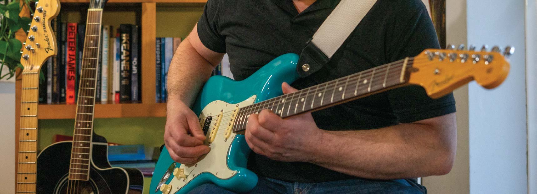 Close-up of a person playing an electric guitar focusing on the hands and fretboard