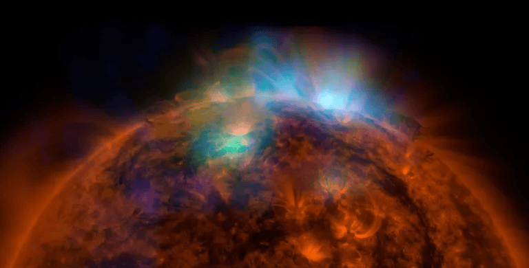 A view of the sun with fiery solar activity, including solar flares and prominences, against a black background.