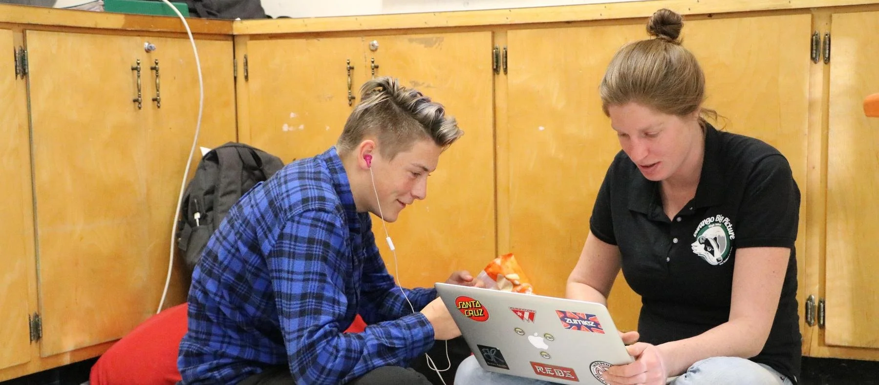 Two people are sitting together collaborating on trauma informed schools.