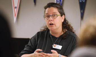 Doty is speaking while gesturing with their hands.