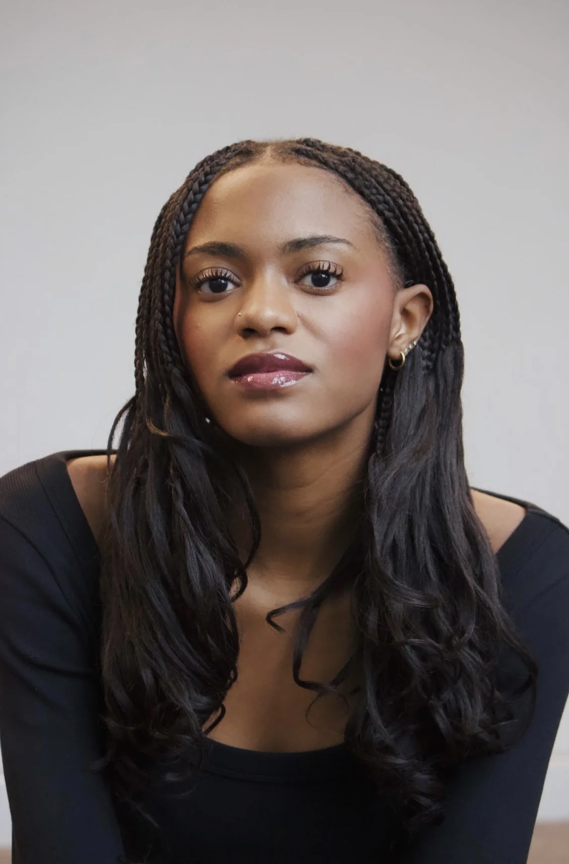 Image of Actor Tia Irby. She is wearing a black shirt with her hair down.