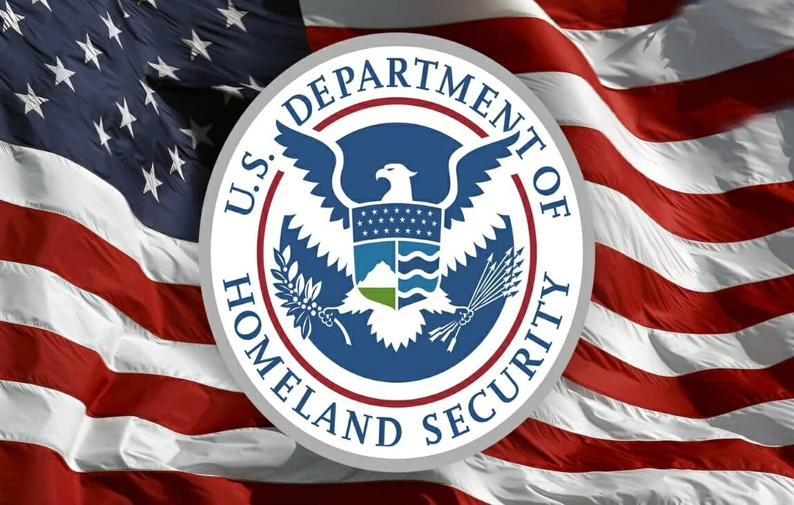 U.S. Department of Homeland Security emblem over an American flag background.