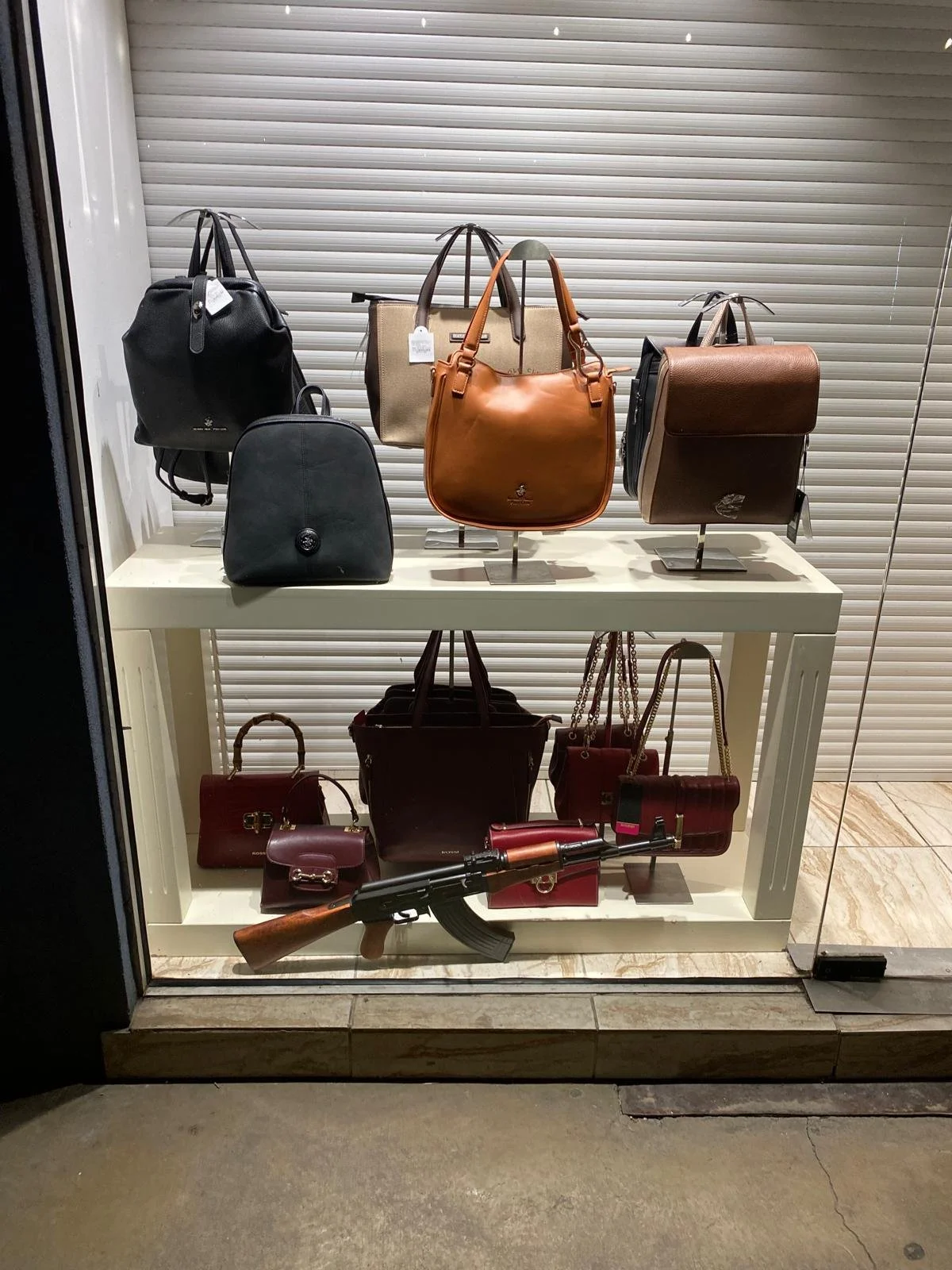 Interesting choice of AK-47 to accentuate the beautiful purses for sale