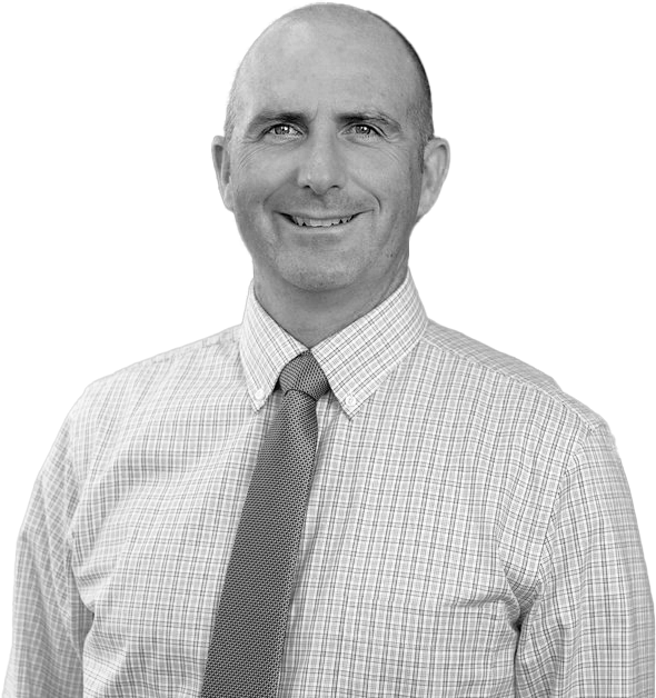 Black and white portrait of a smiling man wearing a checkered shirt and a tie.