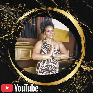 A woman standing with hands in a prayer gesture, smiling, in a room with gold and purple decor, surrounded by a decorative black and gold circular frame with splatters.