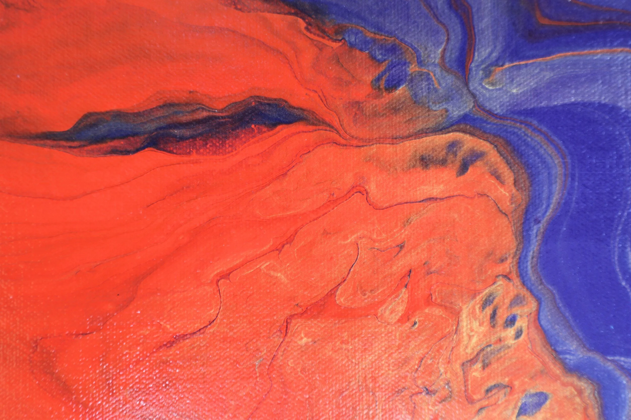 Close-up of a vibrant abstract painting with swirling orange, blue, and black hues.