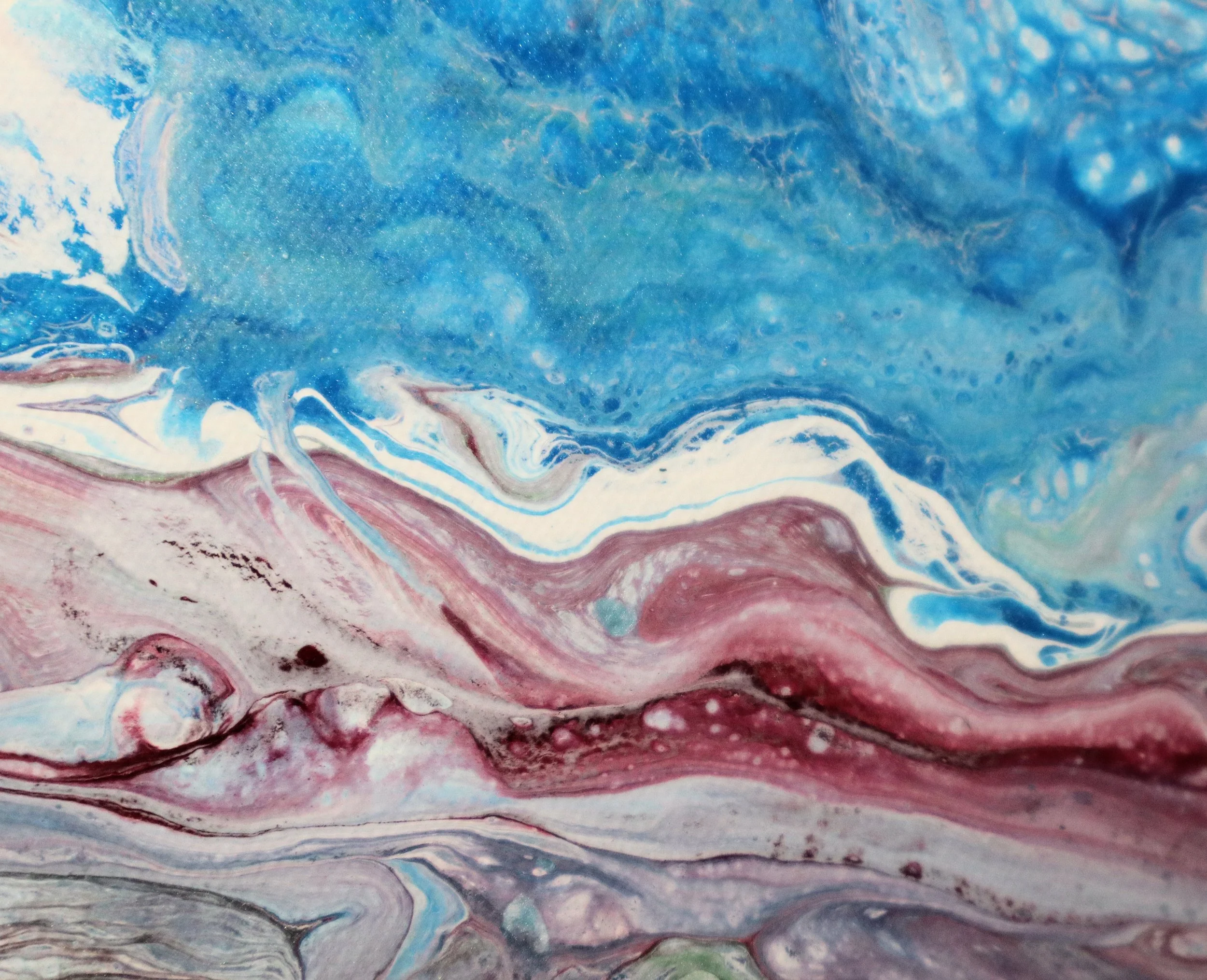 Abstract swirl of blue, pink, red, white, and green colors in a marbled pattern.