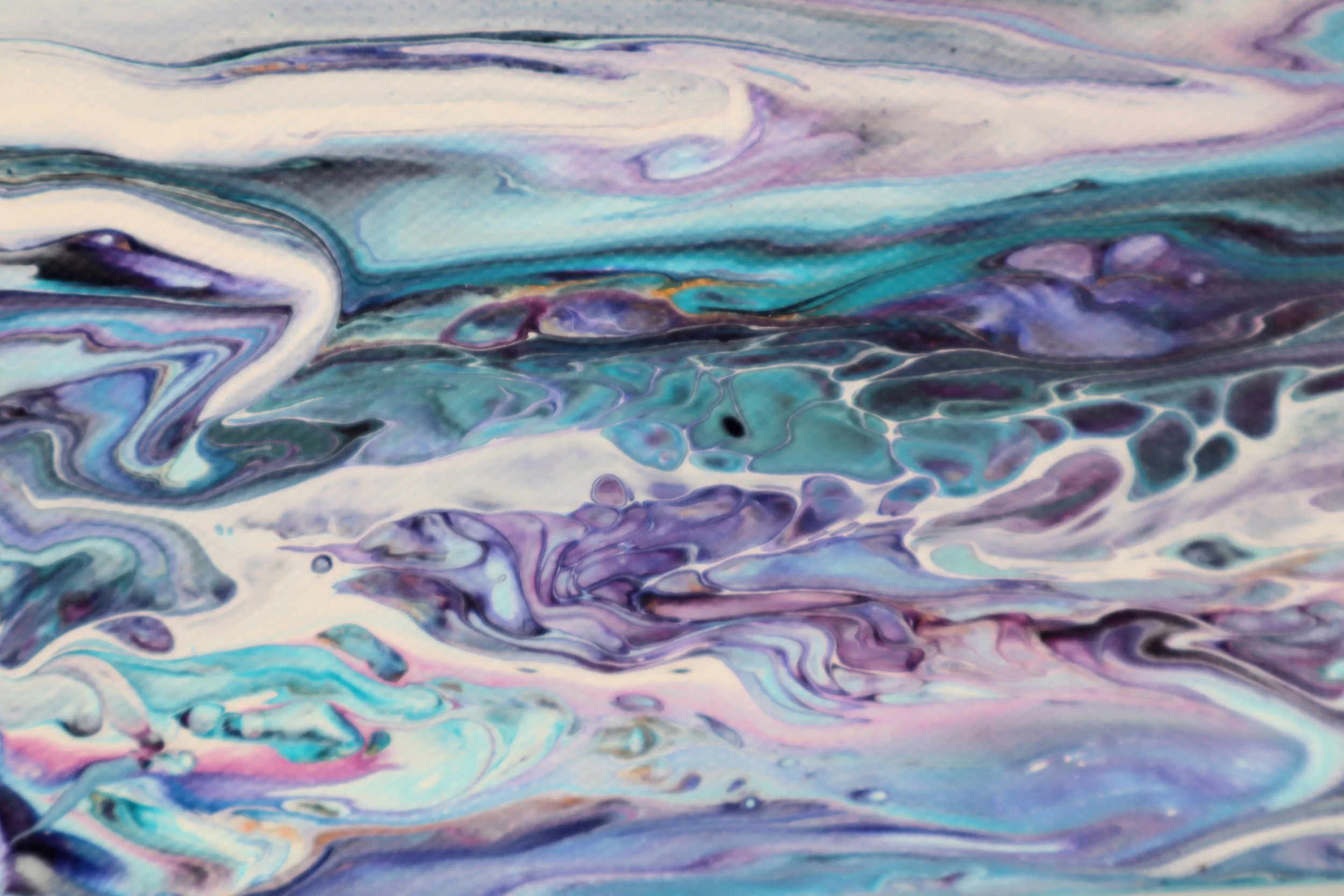 Close-up of a marbled pattern with swirling shades of blue, purple, pink, white, and black.
